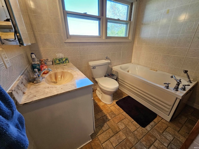 bathroom featuring tile walls, toilet, vanity, and a bathing tub