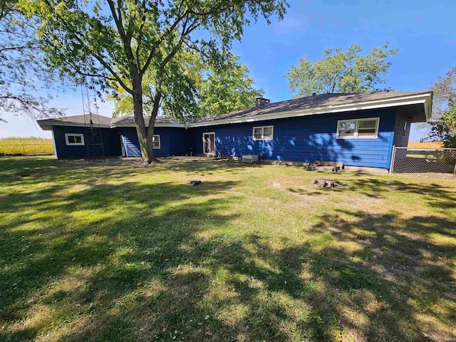 rear view of house featuring a yard