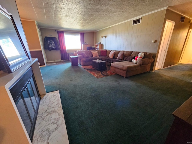 carpeted living room with a textured ceiling, wooden walls, and ornamental molding