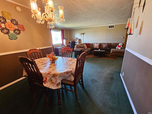 carpeted dining room with an inviting chandelier, a textured ceiling, and ornamental molding