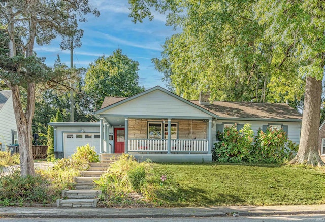 ranch-style house featuring a front yard, a garage, and a porch