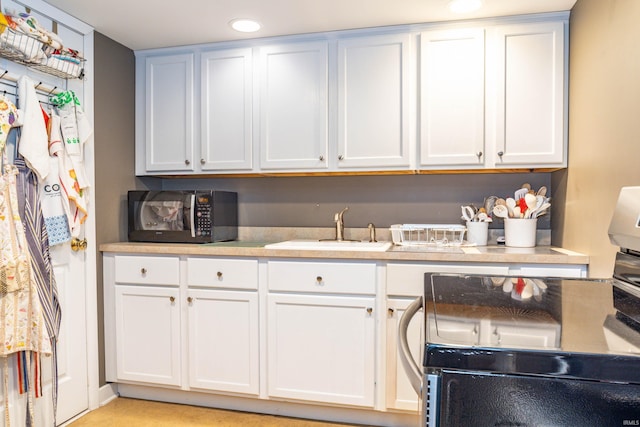 kitchen featuring white cabinetry and sink