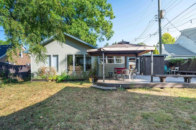 rear view of property featuring a gazebo, a lawn, and a wooden deck