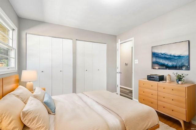 bedroom featuring multiple closets and hardwood / wood-style flooring