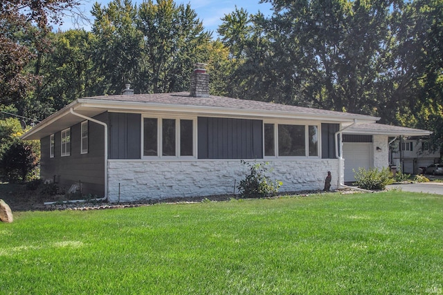 ranch-style house featuring a garage and a front lawn