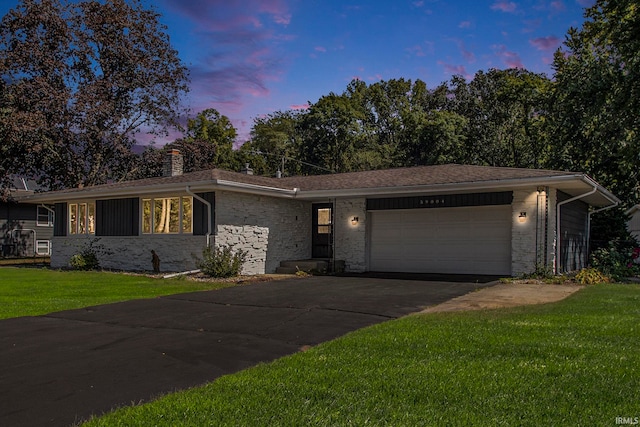 ranch-style home with a yard and a garage