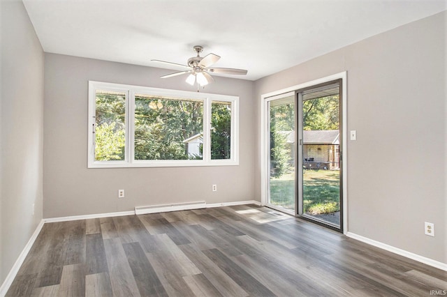 spare room with a baseboard heating unit, ceiling fan, dark hardwood / wood-style floors, and a healthy amount of sunlight