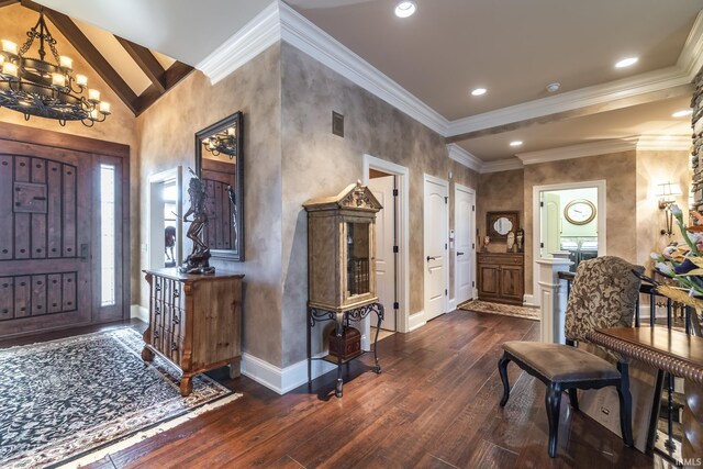 foyer entrance with an inviting chandelier, high vaulted ceiling, dark wood-type flooring, and crown molding