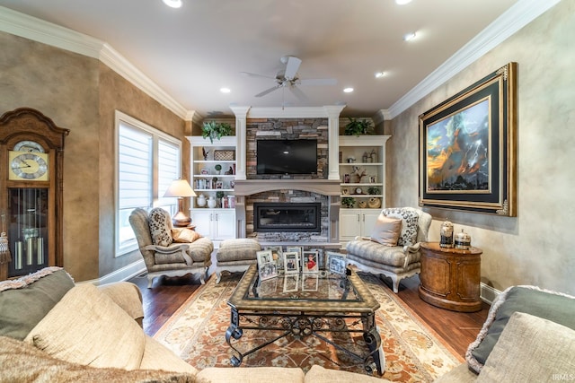 living room with wood-type flooring, a fireplace, ornamental molding, and ceiling fan