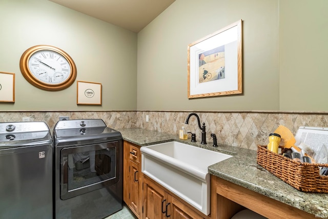 clothes washing area with cabinets, sink, and washing machine and clothes dryer