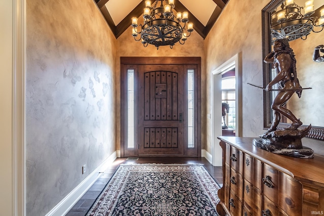 entrance foyer featuring dark wood finished floors, vaulted ceiling, a notable chandelier, and baseboards
