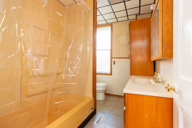 full bathroom featuring a paneled ceiling, vanity, shower / bath combo, parquet floors, and toilet