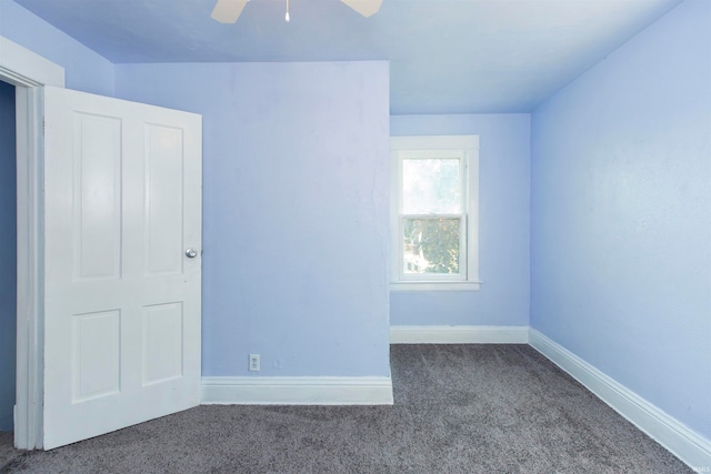 unfurnished room featuring ceiling fan and dark carpet