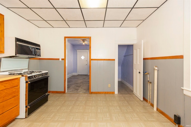 kitchen featuring light parquet floors, black appliances, a drop ceiling, and ceiling fan