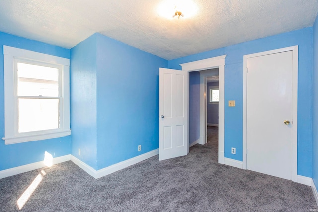 unfurnished bedroom featuring a textured ceiling and carpet flooring