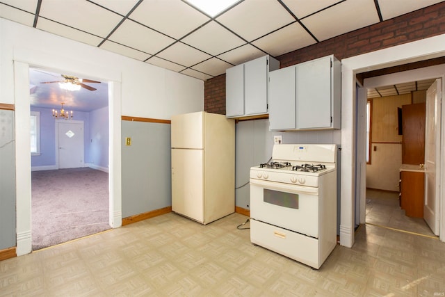 kitchen with ceiling fan, white cabinets, white appliances, brick wall, and light parquet floors