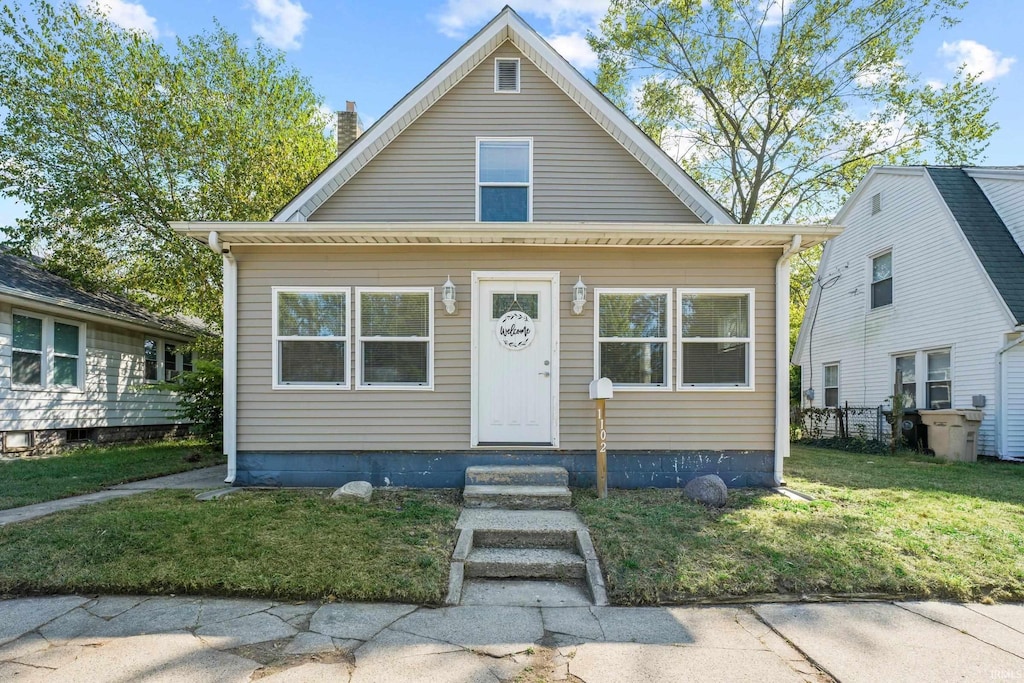 bungalow-style home with a front lawn