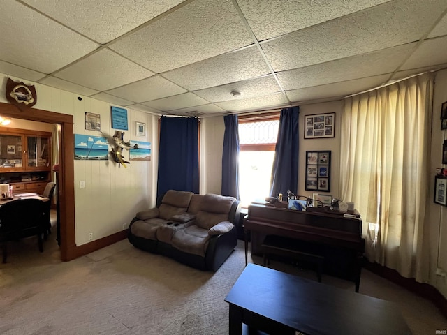 living room featuring carpet floors and a drop ceiling