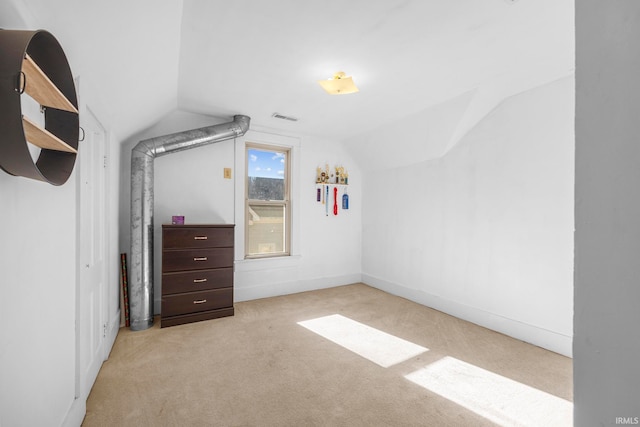 unfurnished bedroom featuring light carpet and vaulted ceiling