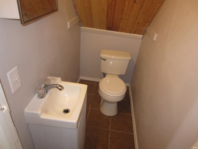 bathroom with wooden ceiling, tile patterned floors, and toilet