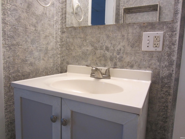 bathroom featuring vanity and tile walls