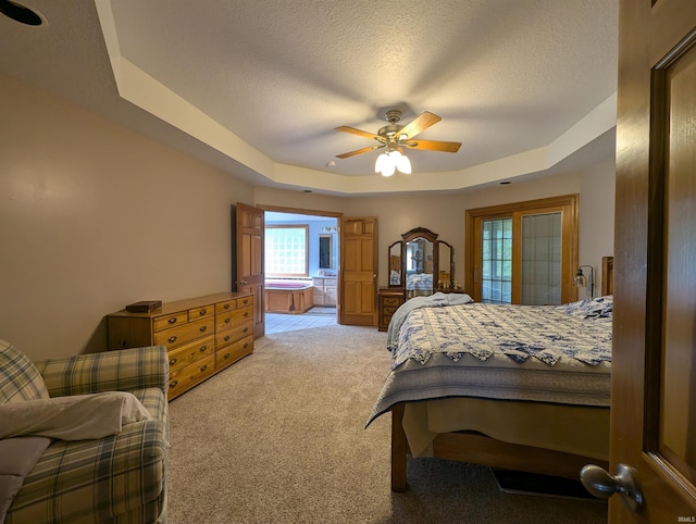 bedroom featuring ceiling fan, light colored carpet, a textured ceiling, and a raised ceiling