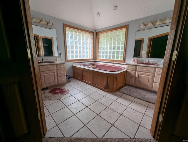 bathroom with vanity, a bathing tub, tile patterned flooring, and a textured ceiling