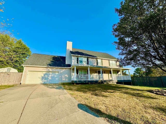 view of front of home featuring a garage, a front lawn, and covered porch