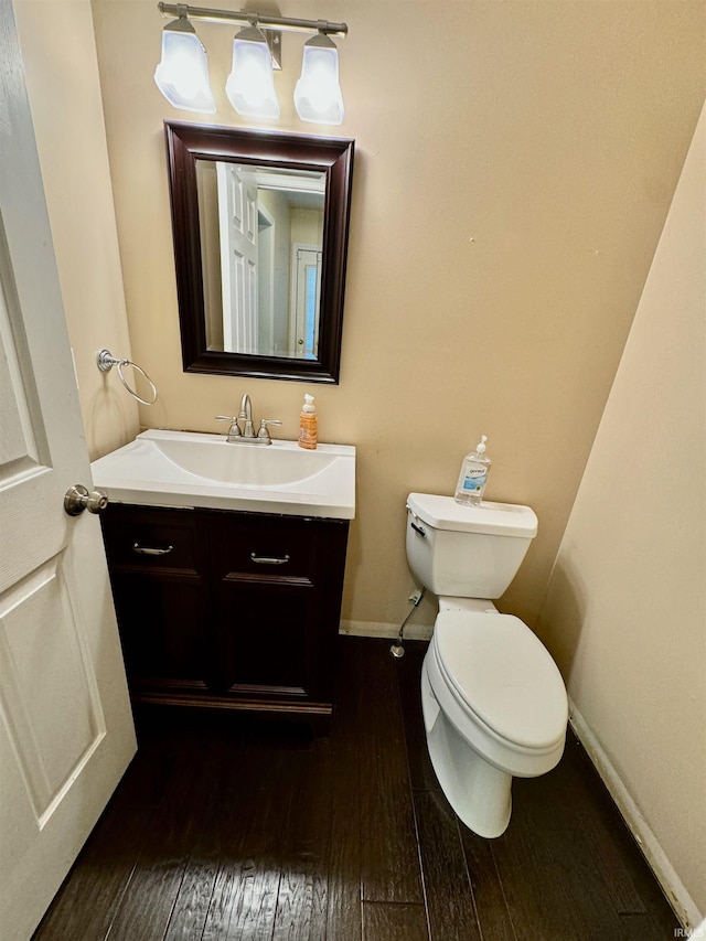 bathroom with vanity, toilet, and hardwood / wood-style flooring