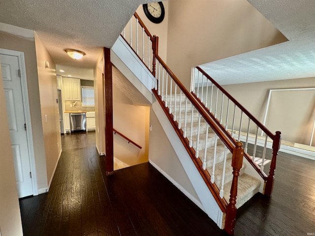 stairway featuring a textured ceiling and hardwood / wood-style flooring