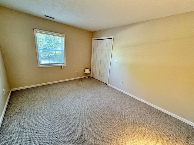 unfurnished bedroom featuring carpet flooring and a closet