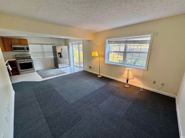 interior space featuring a textured ceiling and light colored carpet