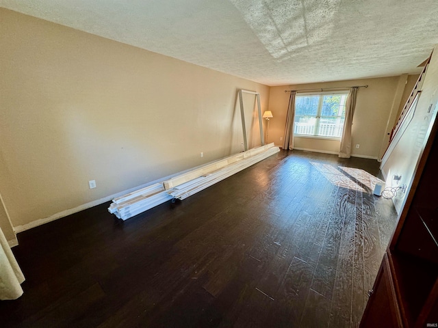 unfurnished bedroom featuring a textured ceiling and dark hardwood / wood-style flooring