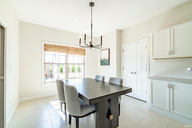 tiled dining space featuring an inviting chandelier and a textured ceiling