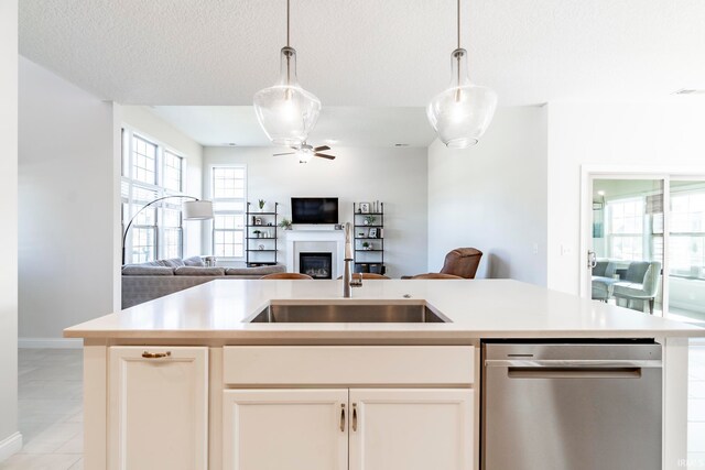 kitchen featuring ceiling fan, sink, a textured ceiling, decorative light fixtures, and white cabinetry