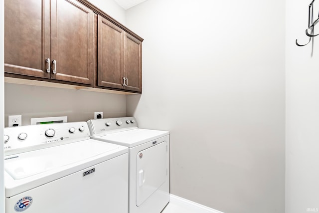 laundry room featuring washing machine and dryer and cabinets