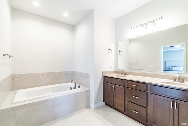 bathroom with tiled tub and vanity