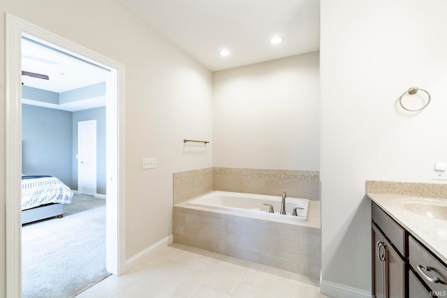 bathroom with tiled bath and vanity