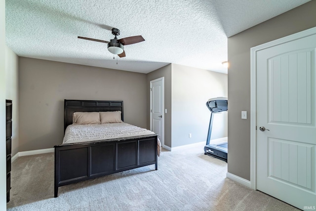 bedroom featuring ceiling fan, light colored carpet, and a textured ceiling