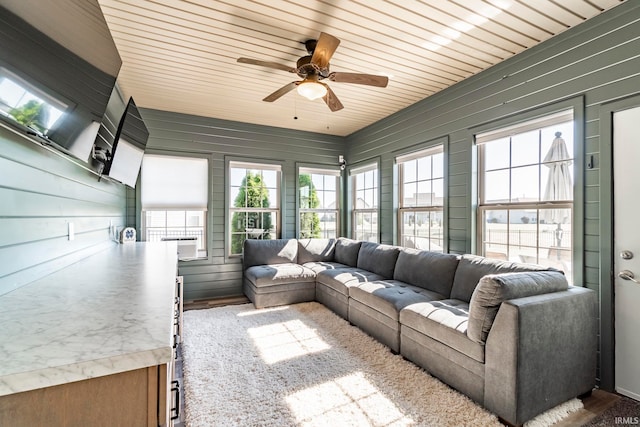 living room featuring ceiling fan, hardwood / wood-style flooring, wood ceiling, and wood walls