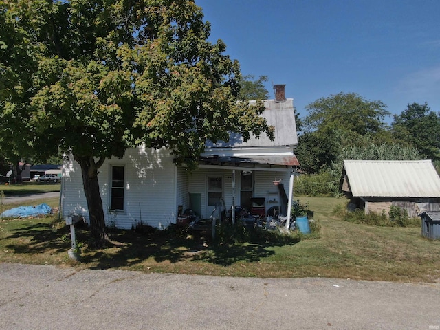 view of property hidden behind natural elements with a front yard