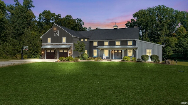 view of front of property with a garage and a lawn