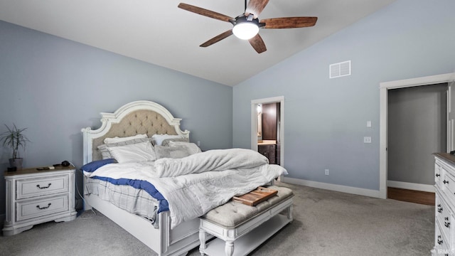 bedroom with light carpet, ensuite bath, ceiling fan, and high vaulted ceiling