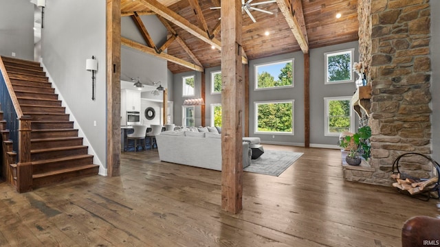 unfurnished living room with hardwood / wood-style flooring, wood ceiling, ceiling fan, and high vaulted ceiling