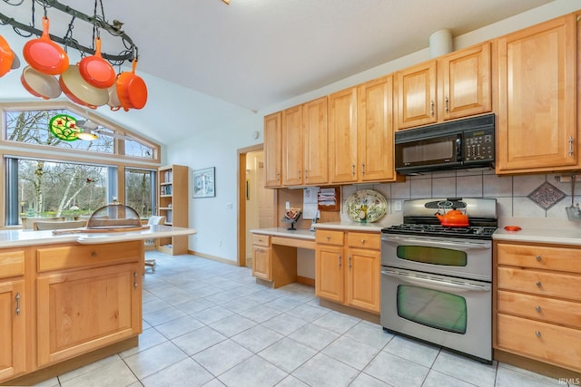 kitchen with light brown cabinets, light tile patterned floors, range with two ovens, vaulted ceiling, and decorative backsplash