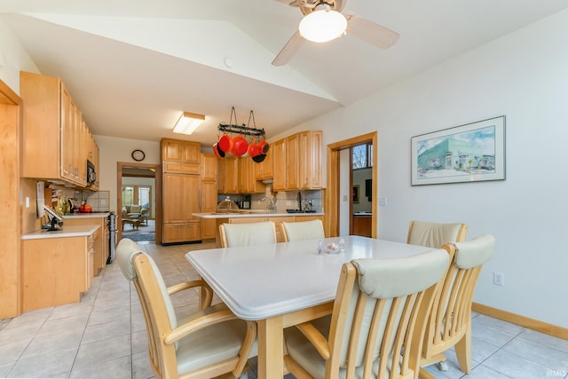 dining area with lofted ceiling, ceiling fan, light tile patterned flooring, and sink