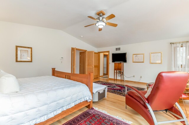 bedroom featuring light hardwood / wood-style flooring, vaulted ceiling, and ceiling fan