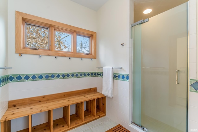 bathroom featuring tile walls, tile patterned flooring, and a shower with shower door