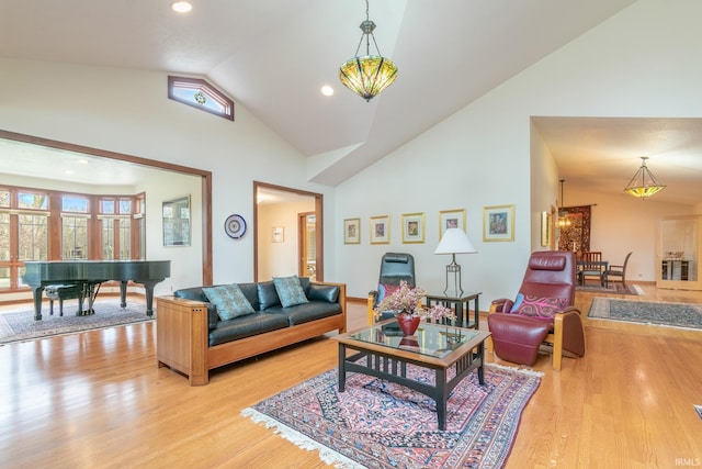 living room featuring light wood-type flooring and high vaulted ceiling