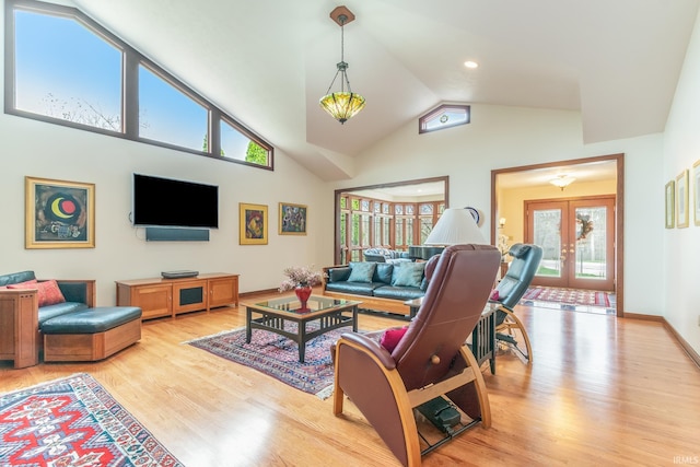 living room featuring light hardwood / wood-style flooring, french doors, and high vaulted ceiling